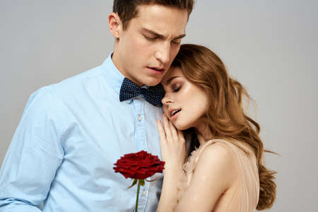 Young couple romance hug relationship dating red rose light studio backgroundの写真素材