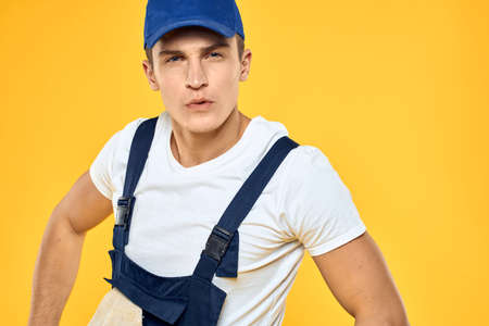 Man in working uniform documents rendering of services delivery service yellow background