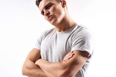 sporty man in white t-shirt on a light background gesturing with his hands cropped view Copy Spaceの写真素材