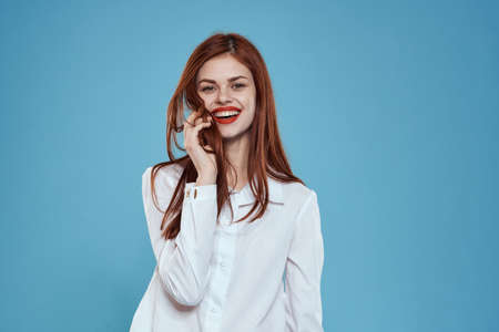 Elegant woman white shirt jeans studio lifestyle blue backgroundの写真素材