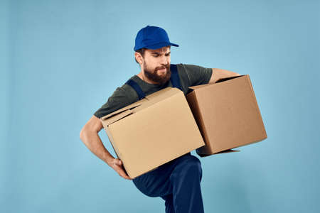 working man boxes in hands delivery service packaging lifestyle blue backgroundの写真素材