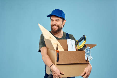 Worker man in uniform box tools construction blue backgroundの写真素材