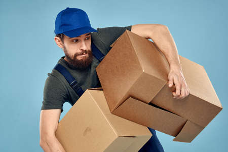 working man boxes in hands delivery service packaging lifestyle blue background
