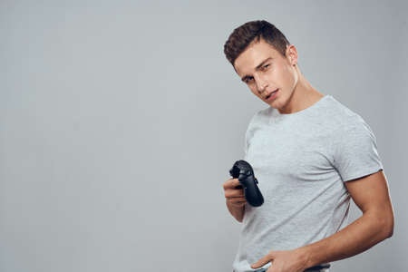 Man with headphones and joystick in hands technology entertainment video games lifestyle addiction light backgroundの写真素材