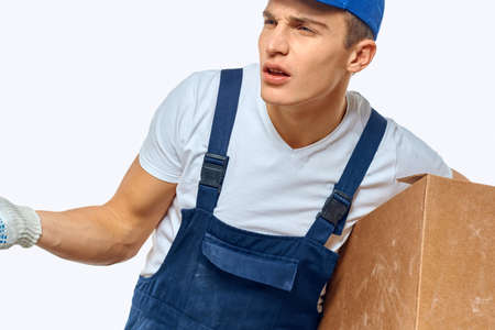 Man worker with box in hands delivery loading service work light backgroundの写真素材