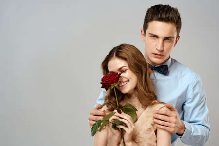 Young couple hugs romance dating lifestyle relationship light background red roseの写真素材