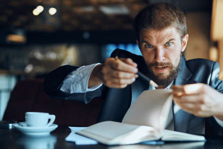 business man sitting at a table in a cafe documents work official coffee cup