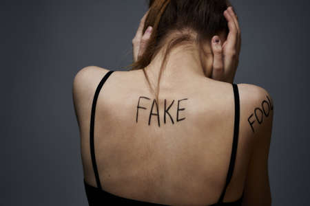 Woman with inscriptions on the body frustration and dissatisfaction emotions lifestyle gray backgroundの写真素材