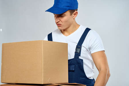 working man in uniform with boxes in his hands delivery loader lifestyleの写真素材