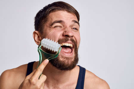 man with a massager in his hand and in a blue t-shirt spa treatments hygiene clean skin emotions...