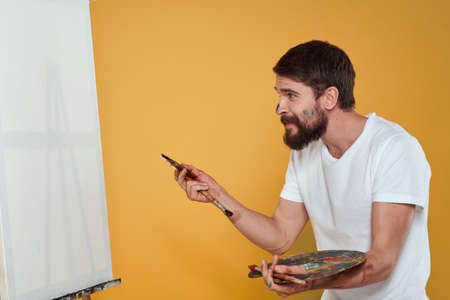 Male artist palette easel drawing hobby lifestyle creativity yellow background