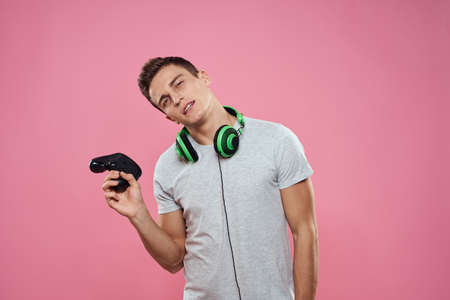 A man with a joystick in his hands headphones playing games entertainment lifestyle white t-shirt...