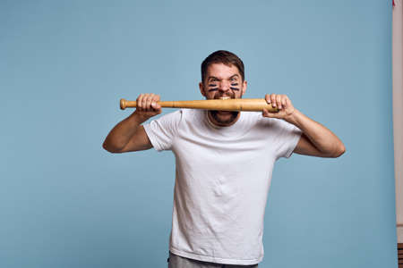 emotional man with a bat in his hand on a blue background and makeup on his face black lines energy t-shirt baseballの写真素材