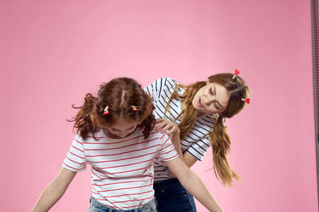 Cheerful mom and daughter joy lifestyle studio pink background familyの写真素材