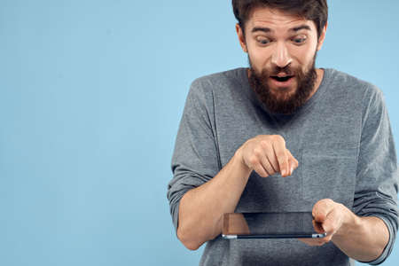 Man with tablet in hands technology lifestyle wireless device blue backgroundの写真素材