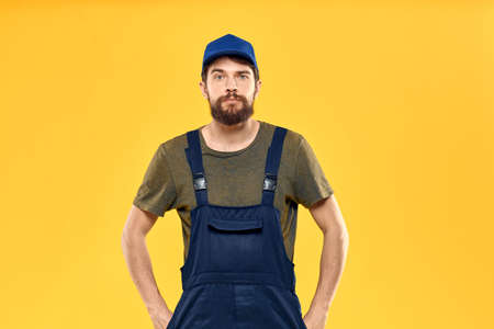 man in work uniform rendering service forklift work lifestyle yellow backgroundの写真素材
