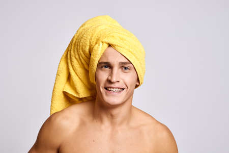 Naked guy with a yellow towel on his head pumped up muscles light background model