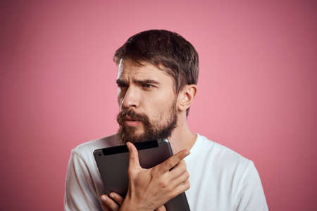 Man advertises a tablet on a pink background codes Space cropped view of emotions white t-shirt...