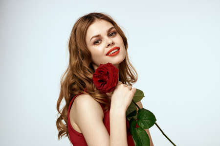 Pretty woman with rose in her handsの写真素材