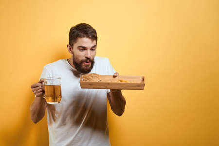 Bearded man with mug of beer fast food diet food fun alcohol lifestyle yellow background