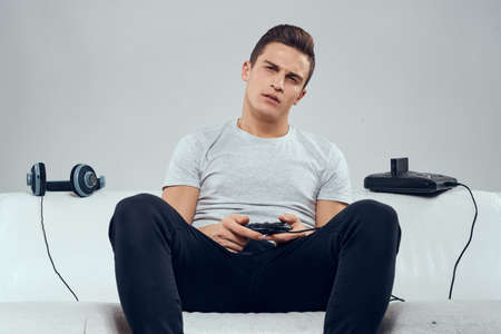 Man sitting on the couch headphones joystick games entertainment addiction leisure technology