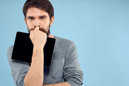 Emotional man with a tablet in the hands of a wireless device internet technology lifestyle blue...