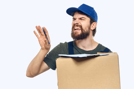 Working male courier with box in hand documents delivery service light backgroundの写真素材