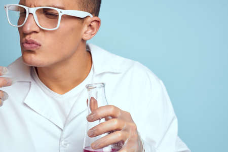 man holding flasks colorful liquid chemical laboratory model wearing glasses