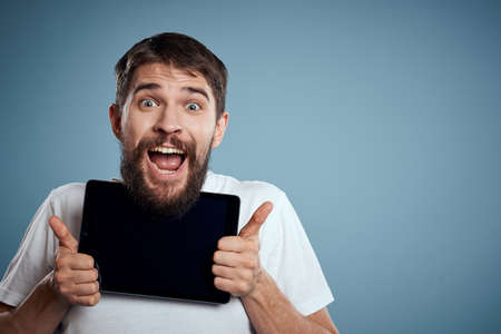 man with tablet near face on blue background cropped view touch monitor new technologies Copy Space