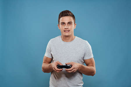 A man with a joystick in his hands entertainment leisure technology video games blue background...