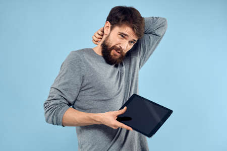 Man holding tablet in hands wireless technology internet lifestyle studio blue background emotions
