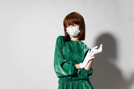 Fashion female coronavirus, model posing with gloves and protective medical mask