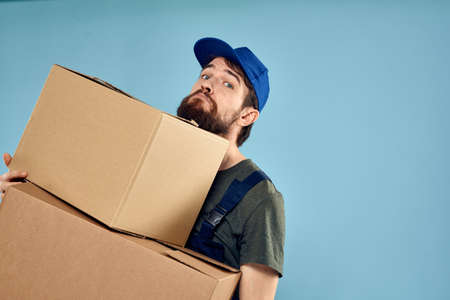 working man boxes in hands delivery service packaging lifestyle blue background