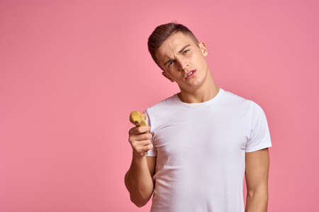 Man with fruits in hands on a pink background healthy food vitamins pink background white t-shirt modelの写真素材