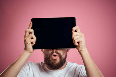 Man advertises a tablet on a pink background codes Space cropped view of emotions white t-shirt...