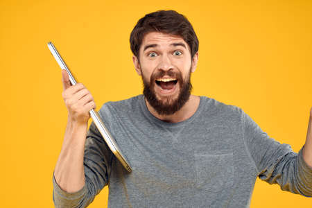 man with laptop wireless technology internet lifestyle work yellow isolated background