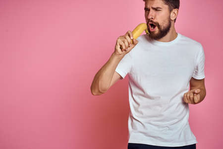 bearded man with banana in hand on pink background fun emotions model