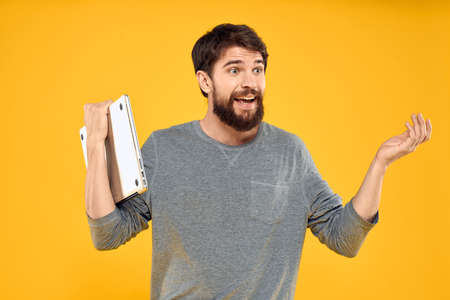 man with laptop wireless technology internet lifestyle work yellow isolated background