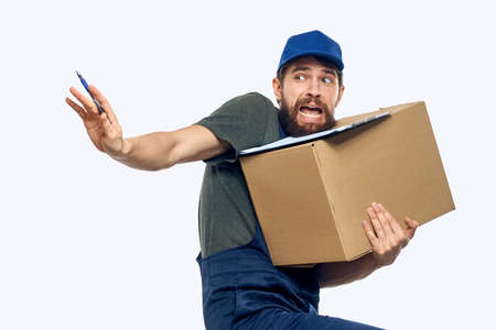 Working male courier with box in hand documents delivery service light backgroundの写真素材