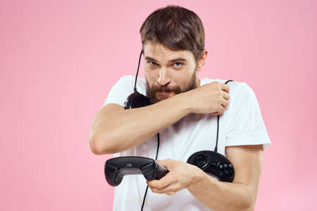 Man with two joysticks in hands fun game technology lifestyle pink background