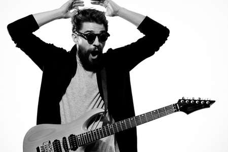 man with guitar in hands musician rock star performance lifestyle light background