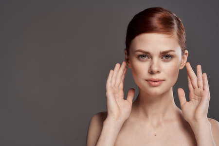 Beautiful woman naked shoulders cosmetics clean skin charm gray background studioの写真素材