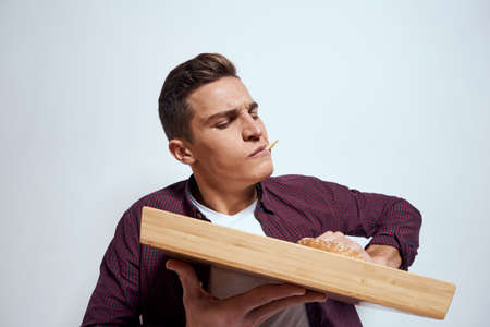 Man eating wooden pallet fast food french fries hamburger diet food restaurant light background