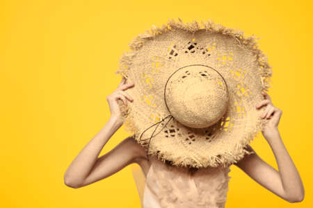 Portrait woman in straw hat on yellow background cropped view of summer dress model pigtails romance
