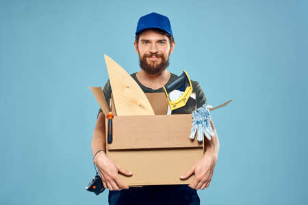 Worker man in uniform box tools construction blue background