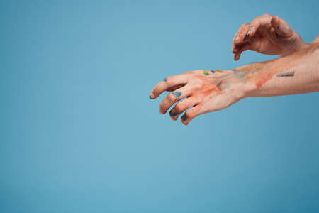 Artists hands paint close-up blue background drawing hobbyの写真素材