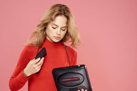 Woman with video game attachment lifestyle entertainment lifestyle pink backgroundの写真素材