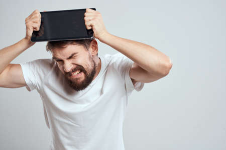 emotional man with tablet in hand touch screen new technologies light background cropped view Copy Spaceの写真素材