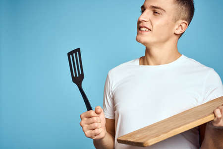 energetic guy with wooden kitchen board and spatula fun emotionsの写真素材