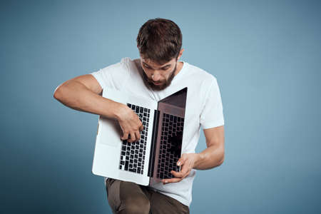 Man shows open laptop keyboard monitor emotions model blue advertising background Copy Spaceの写真素材